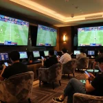 Engaged bettors using keonhacai resources in a lively sports betting lounge for enhanced gameplay